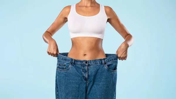 Closeup Of Skinny Woman Pulling Large Loose Jeans — Stok Foto