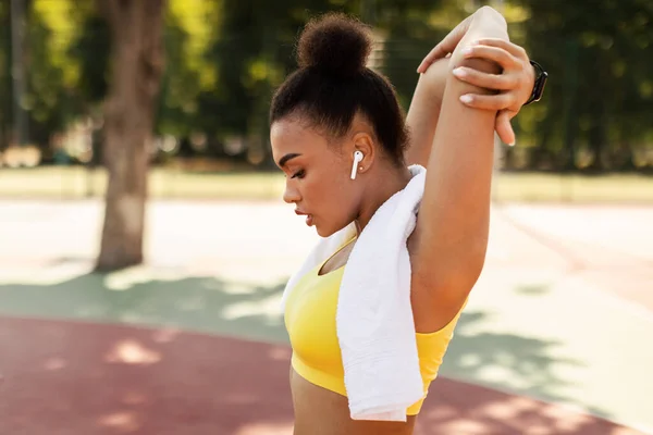 Deportiva mujer negra en ropa deportiva amarilla estirando los brazos, warmup — Foto de Stock