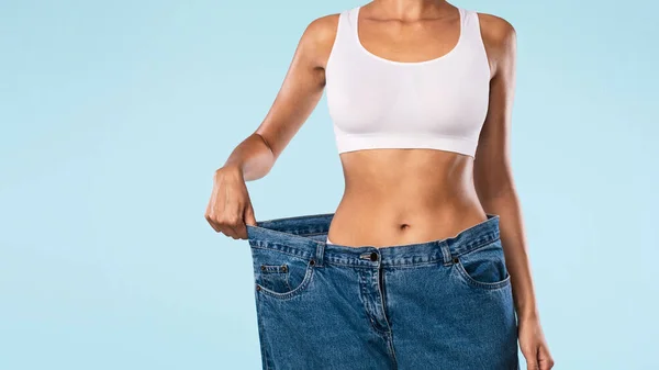 Close Up Of Woman Pulling Her Old Large Loose Jeans