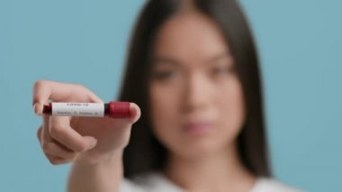 Covid-19 testi için Asyalı Kadın Kan Taşıyıcı, Mavi Arkaplan