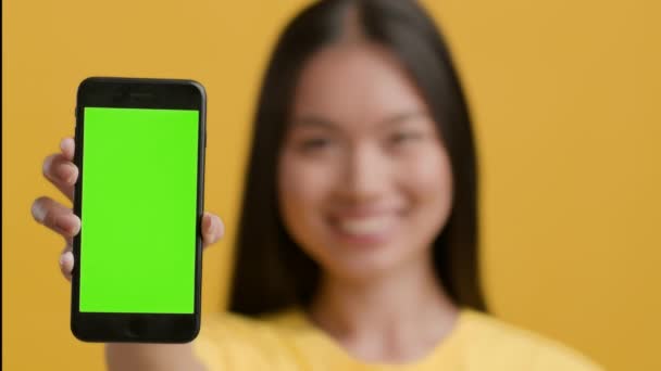 Akıllı Telefon Gösteren Koreli Kadın Yeşil Krom Anahtar Ekranı, Sarı Arkaplan — Stok video