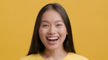 Neşeli Çinli Kadının Portresi Kameraya Gülümsüyor, Sarı Arkaplan