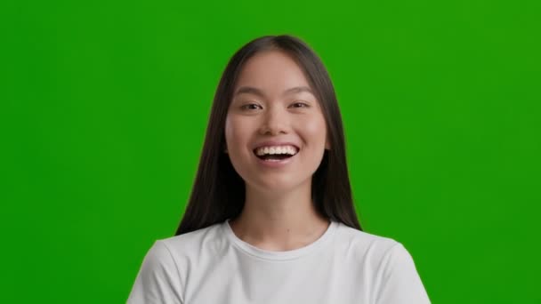 Happy Asian Millennial Kobieta uśmiechnięta pozowanie na zielonym tle Studio — Wideo stockowe