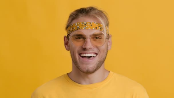 Portrait Of Cheerful Dancing Hippie Guy Wearing Headband And Colorful Sunglasses — Stock Video