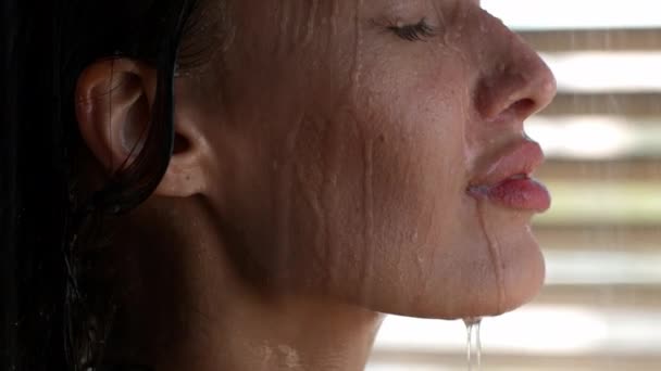 Mulher desfrutando de chuveiro posando com gotas de água no rosto interior — Vídeo de Stock