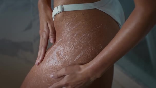 Oigenkännlig kvinna Tillämpa skrubb på höfter vårda huden inomhus — Stockvideo