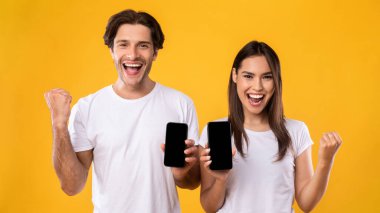 Çift iki tane boş akıllı telefon ekranı gösteriyor ve işaret ediyor.