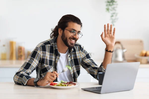 Positivo uomo medio-orientale che fa videochiamate durante la colazione a casa — Foto Stock