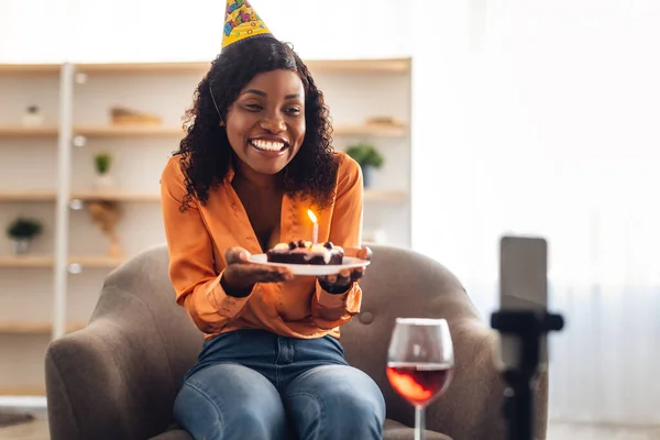 Afrikaanse vrouw Holding verjaardag taart in de buurt van telefoon Celebating Online Indoor — Stockfoto