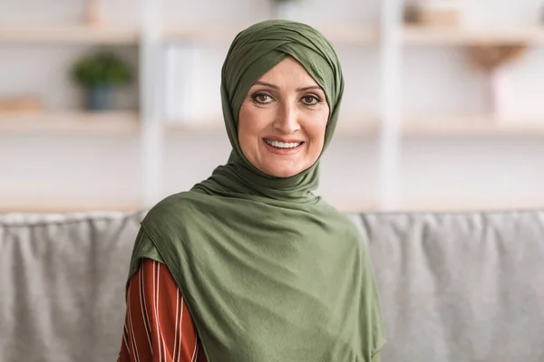 Retrato de la mujer madura de Oriente Medio feliz usando Hijab en casa —  Fotos de Stock