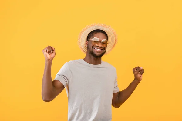 Sommarklubba. glad afrikansk amerikansk man dansar till favoritmusik över gul studio bakgrund — Stockfoto