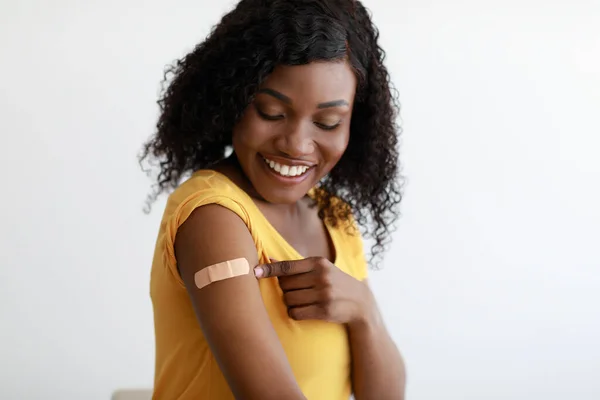 Ковід-19 вакцинована чорна жінка, що показує руку після ін'єкції вакцини, 1-кімнатна — стокове фото