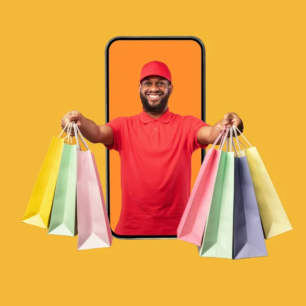 Black Courier On Phone Screen Giving Shopper Bags, Yellow Background — стокове фото