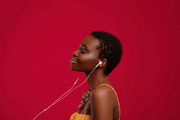 Kulaklıklı neşeli Afro-Amerikan bayan müzik dinliyor. — Stok fotoğraf