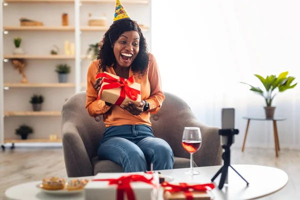Afro-Amerikaanse vrouw praten met Smartphone Holding Verjaardag Gift Indoor — Stockfoto