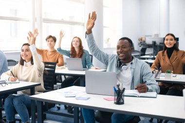 Seminerde gülümseyen çeşitli insanların el kaldırma portresi