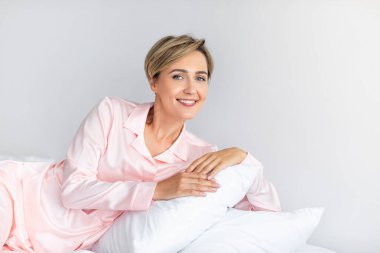 Mutlu olgun kadın uyandıktan sonra kameraya bakıyor.