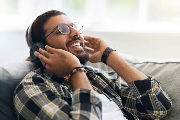 Närbild av glad mellanösternkille lyssnar på musik — Stockfoto