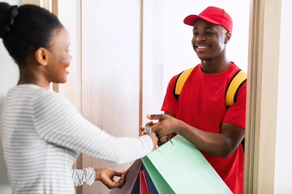 Afrikanerin Shopaholic erhält Einkaufstüten von fröhlichem Lieferanten — Stockfoto