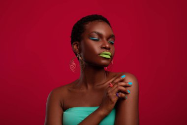 Kırmızıda poz veren çekici siyahi kadın.