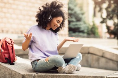 Diz üstü bilgisayar kullanan Afrikalı Amerikalı Kız Öğrenci Dışarıdan Görüntü Aranıyor