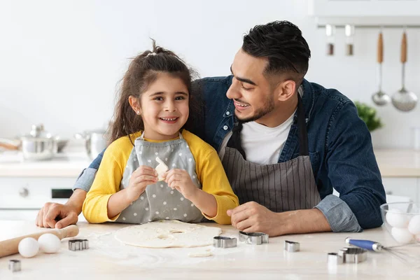Küçük mutlu Arap kız babasıyla mutfakta yemek pişiriyor. — Stok fotoğraf