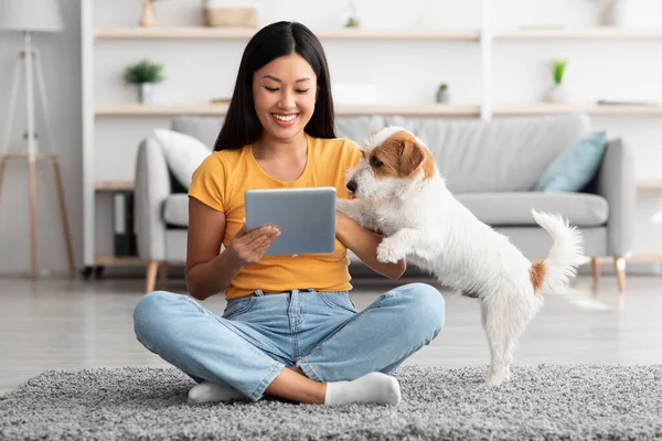 Asiatisk kvinna och söt hund har roligt tillsammans hemma — Stockfoto