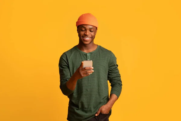 いいアプリだ。スマートフォンを使って幸せな若い黒人男性、新しいアプリケーションを閲覧 — ストック写真