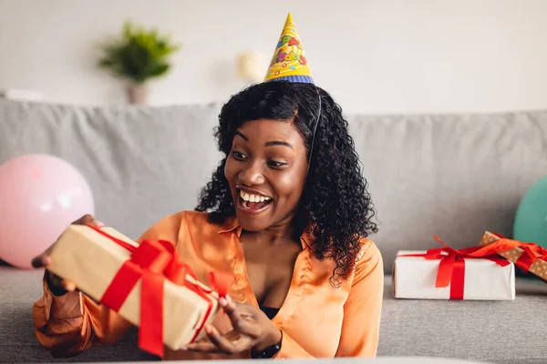 Black Woman Opening Wrapped Birthday Gift Box Di Rumah — Stok Foto