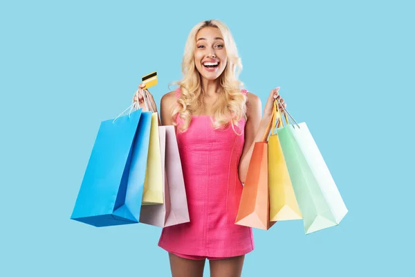 Szczęśliwa kobieta trzyma kartę kredytową z torbami na zakupy — Zdjęcie stockowe