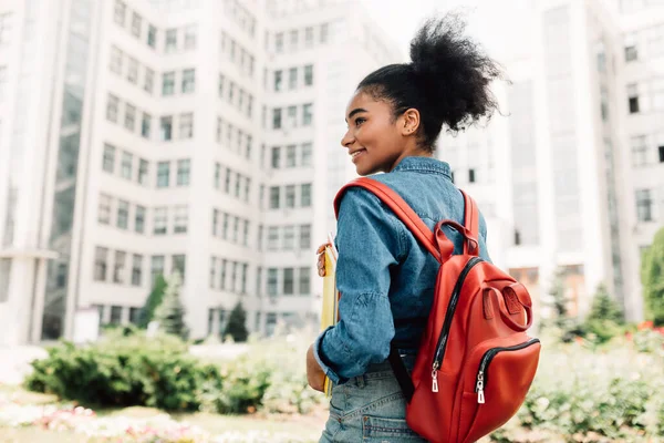 Student Girl Posing med ryggsäck stående tillbaka till kameran utanför — Stockfoto