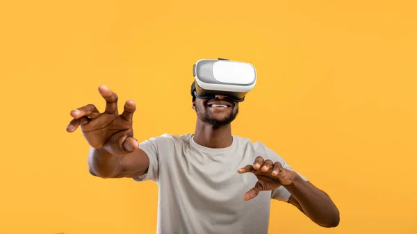 Virtuele ervaring. Gelukkig Afrikaans amerikaanse man dragen VR headset, het aanraken van lucht tijdens het spelen van video game — Stockfoto