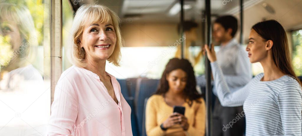 Beautiful smiling mature woman taking bus, looking out of window