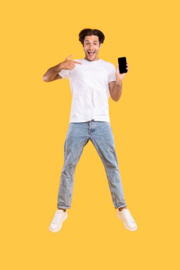 Beyaz, boş, akıllı telefon ekranı gösteren ve zıplayan adam