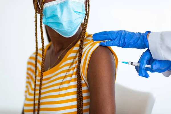 Поранені афроамериканки з масками обличчя отримують вакцинацію. — стокове фото