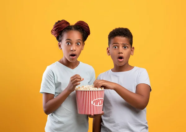 Schockierte schwarze Kinder Junge und Mädchen essen Popcorn — Stockfoto