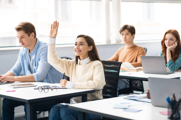 Porträtt av kvinnliga student höja handen i klassrummet — Stockfoto