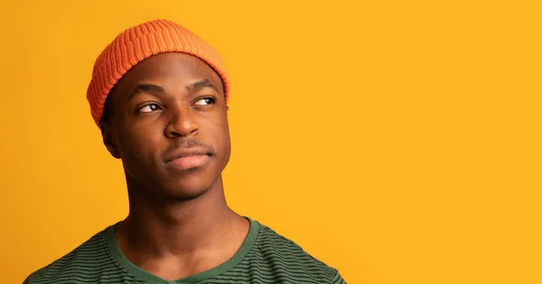 Serios jóvenes negro chico en naranja sombrero mirando a un lado en copia espacio — Foto de Stock