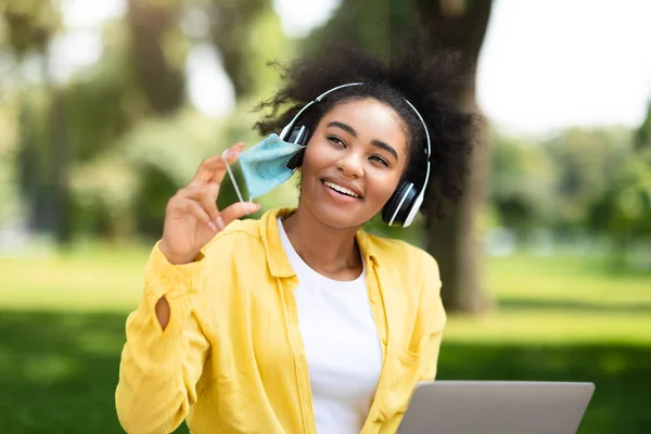 Alegre africano americano estudiante chica tomando off cara máscara al aire libre — Foto de Stock