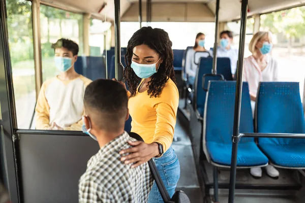 Señora negra con máscara protectora hablando con su hijo en autobus —  Fotos de Stock