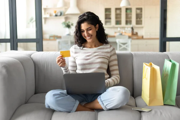 Concepto de cibercompra. Joven dama caucásica con portátil y tarjeta de crédito ordenando cosas en línea en casa — Foto de Stock