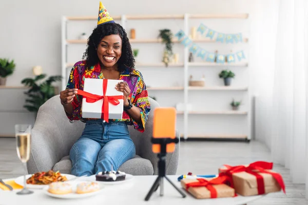 Mutlu Siyah Kadın Evde Telefon İçin Doğum Günü Hediye Kutusunu Gösteriyor — Stok fotoğraf