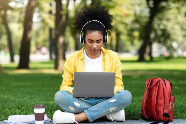Estudiante africana chica viendo conferencia sobre el aprendizaje del ordenador portátil en línea fuera — Foto de Stock