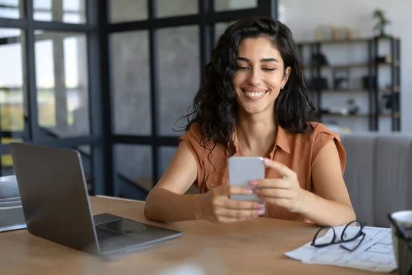 Felice giovane signora caucasica utilizzando smartphone e laptop per il lavoro online a casa, copia lo spazio — Foto Stock