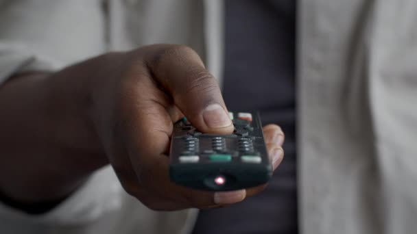 Черный человек нажимает кнопку на телевизоре — стоковое видео