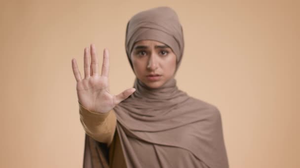 不幸な犠牲者ムスリム女性ベージュの背景の上に立つジェスチャー停止 — ストック動画