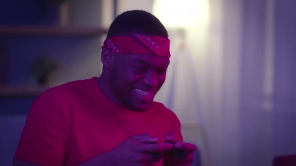 Счастливый чернокожий парень играет в игру и выигрывает дома — стоковое видео