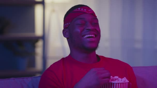 Nero ragazzo guardando film ridendo mangiare popcorn all'aperto di notte — Video Stock