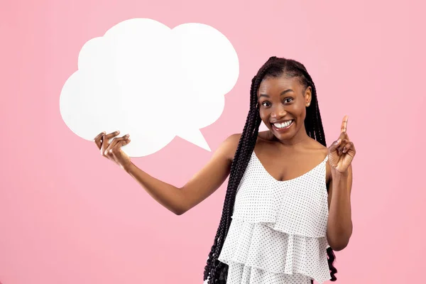 Mujer negra positiva con racimos afro sosteniendo burbuja de habla en blanco, haciendo gesto IDEA sobre fondo rosa, maqueta —  Fotos de Stock