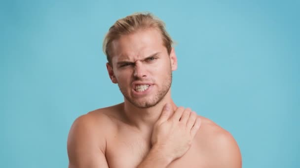 Joven infeliz masajeando el cuello y los hombros, sufriendo de dolor muscular — Vídeo de stock
